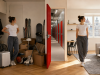 Young woman in the same small Budapest apartment before and after decluttering, with a City Storage corridor between the two scenes