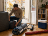 Large suitcase, packed tent, rolled SUP, pump, cooler box and beach umbrella being prepared for autumn storage in a Budapest flat